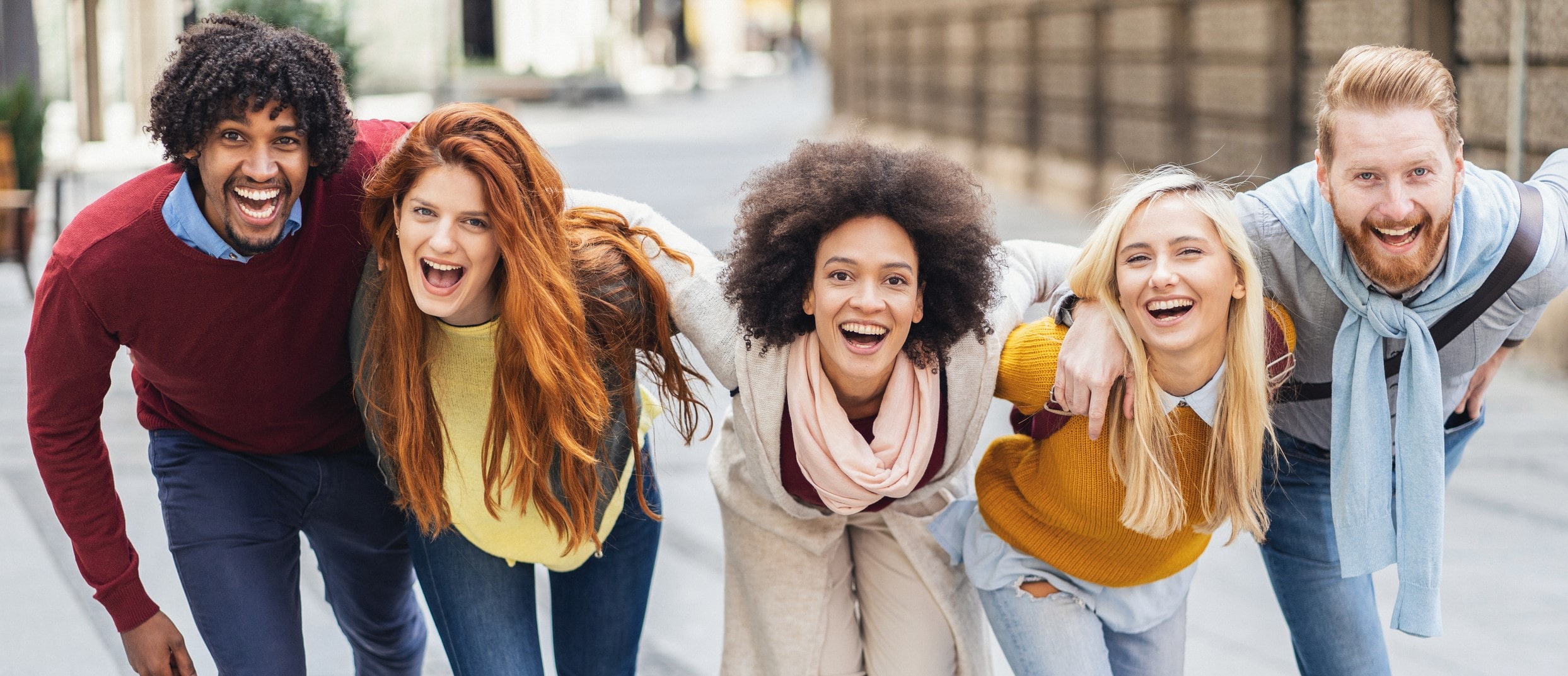 group of friends outside, linked arm to arm